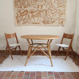 Deux chaises vintage en hêtre massif des années 50 avec assise en tissu bouclette clair, design épuré à la René-Jean Caillette, présentées seules et en mise en situation.