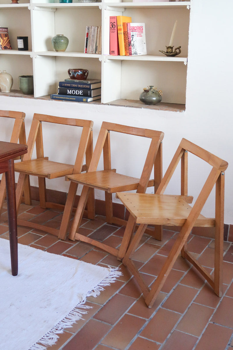 Quatre chaises pliantes en bois massif années 70 style Aldo Jacober avec dossier épais et assise à lattes.