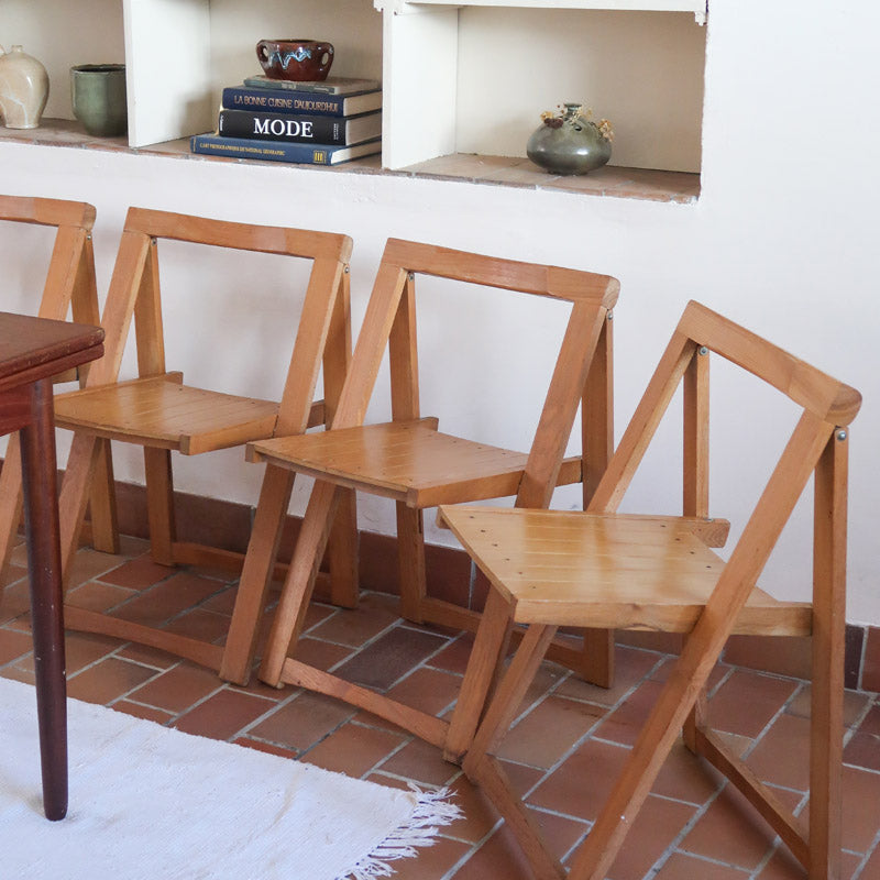 Quatre chaises pliantes en bois massif années 70 style Aldo Jacober avec dossier épais et assise à lattes.