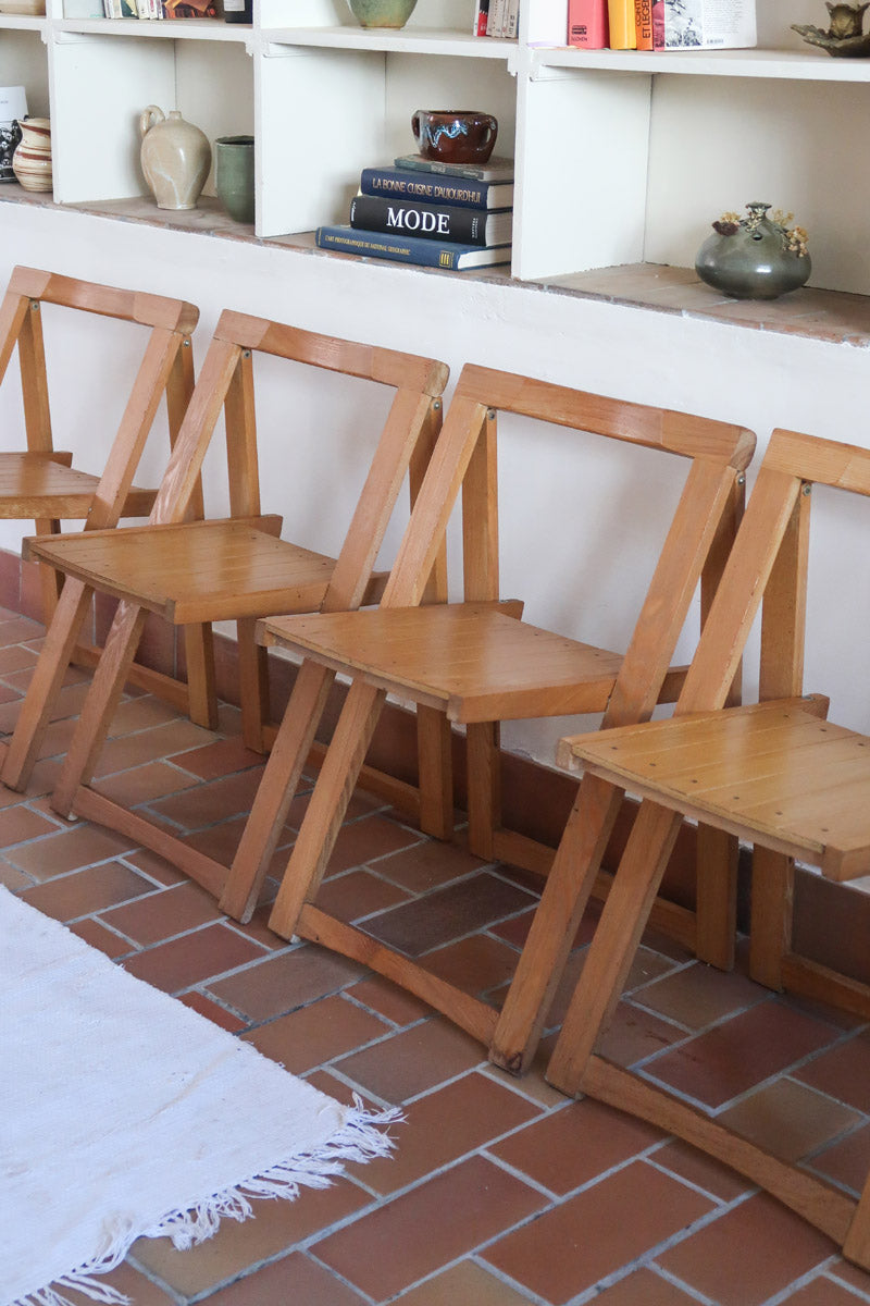 Quatre chaises pliantes en bois massif années 70 style Aldo Jacober avec dossier épais et assise à lattes.