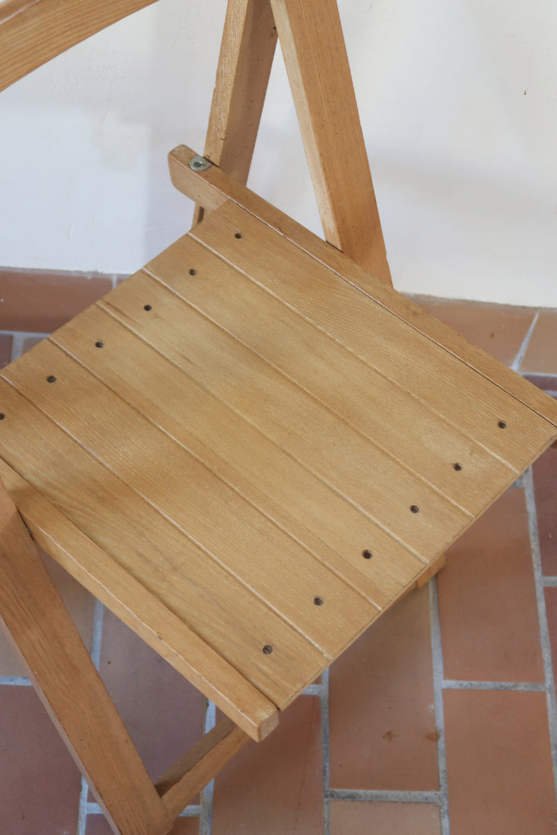 Quatre chaises pliantes en bois massif années 70 style Aldo Jacober avec dossier épais et assise à lattes.