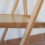 Quatre chaises pliantes en bois massif années 70 style Aldo Jacober avec dossier épais et assise à lattes.