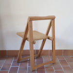 Quatre chaises pliantes en bois massif années 70 style Aldo Jacober avec dossier épais et assise à lattes.