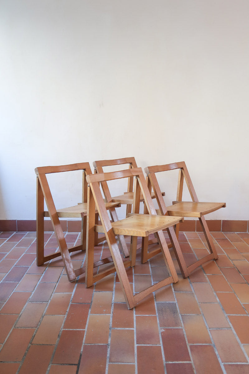 Quatre chaises pliantes en bois massif années 70 style Aldo Jacober avec dossier épais et assise à lattes.