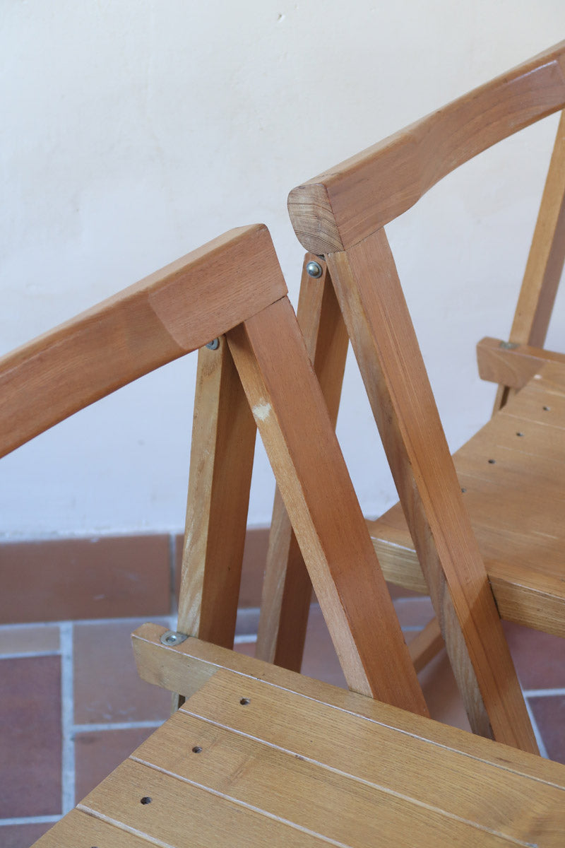 Quatre chaises pliantes en bois massif années 70 style Aldo Jacober avec dossier épais et assise à lattes.