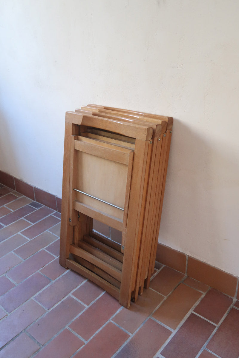 Quatre chaises pliantes en bois massif années 70 style Aldo Jacober avec dossier épais et assise à lattes.