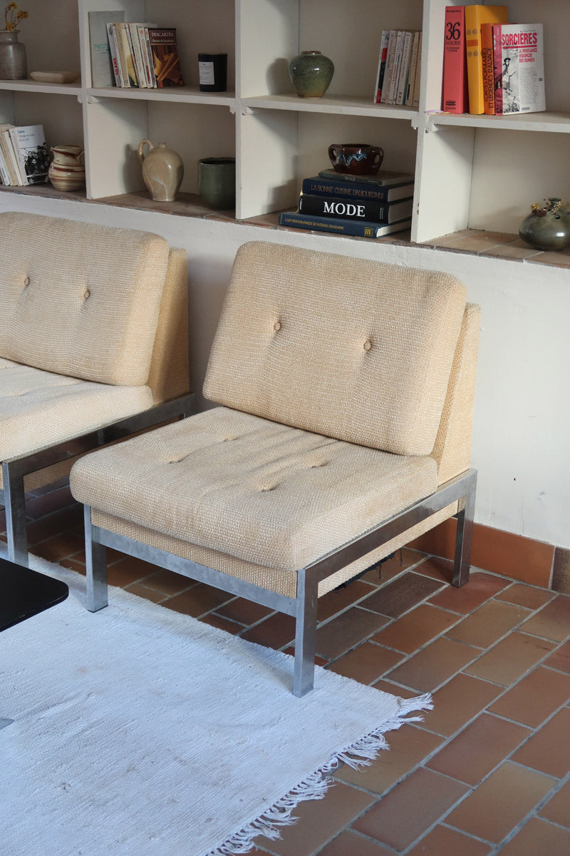 Paire de chauffeuses modernistes années 70 en acier avec tissu beige d’origine et dossier capitonné.