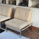 Paire de chauffeuses modernistes années 70 en acier avec tissu beige d’origine et dossier capitonné.