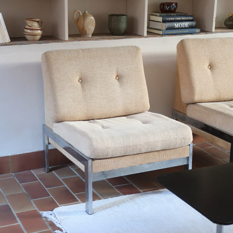 Paire de chauffeuses modernistes années 70 en acier avec tissu beige d’origine et dossier capitonné.