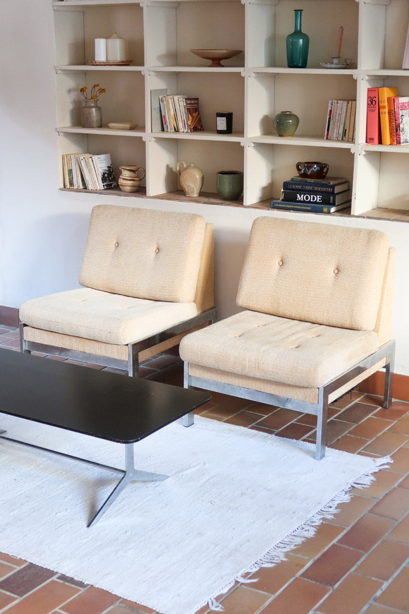 Paire de chauffeuses modernistes années 70 en acier avec tissu beige d’origine et dossier capitonné.