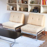 Paire de chauffeuses modernistes années 70 en acier avec tissu beige d’origine et dossier capitonné.