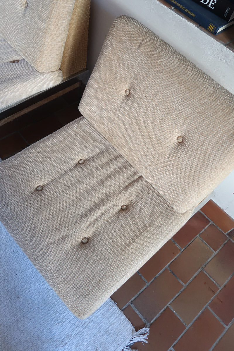 Paire de chauffeuses modernistes années 70 en acier avec tissu beige d’origine et dossier capitonné.