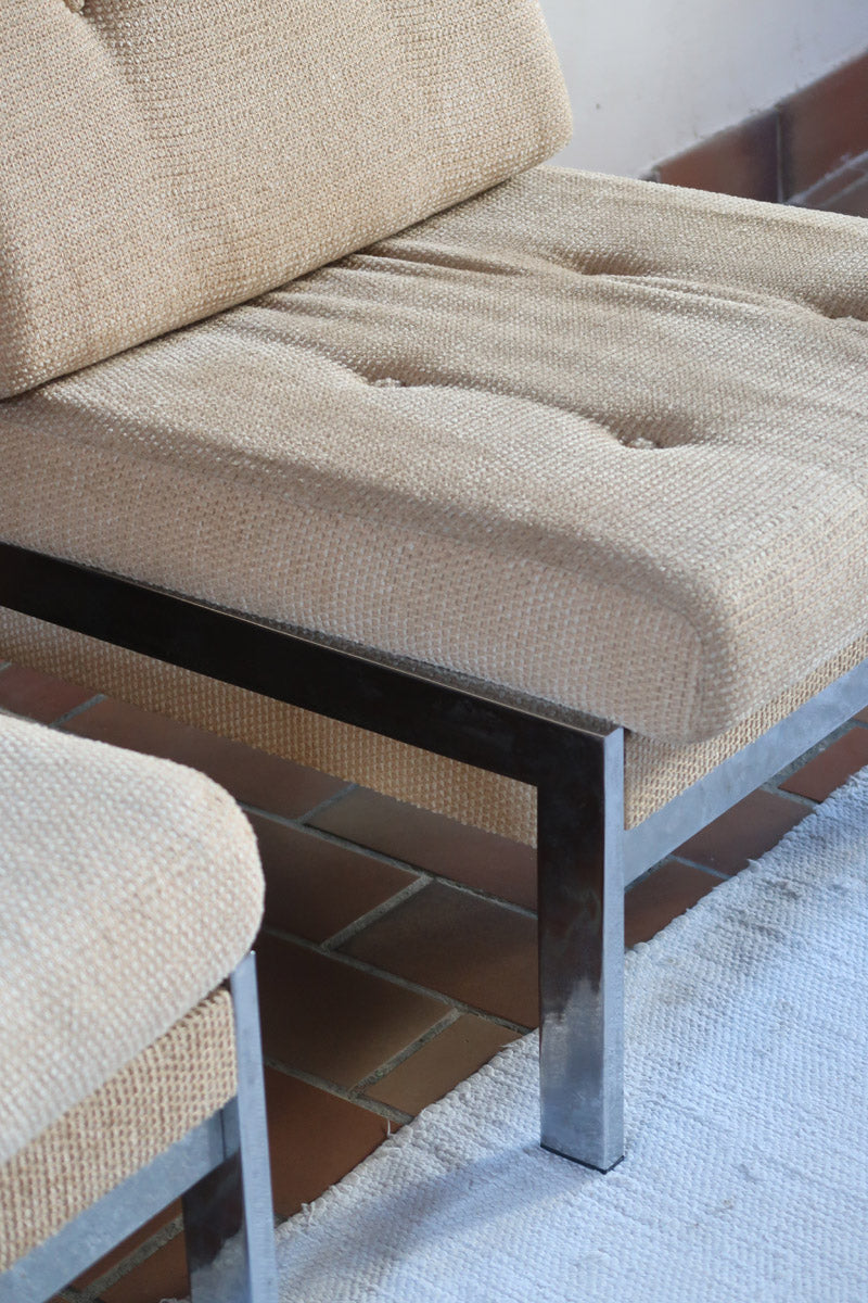 Paire de chauffeuses modernistes années 70 en acier avec tissu beige d’origine et dossier capitonné.