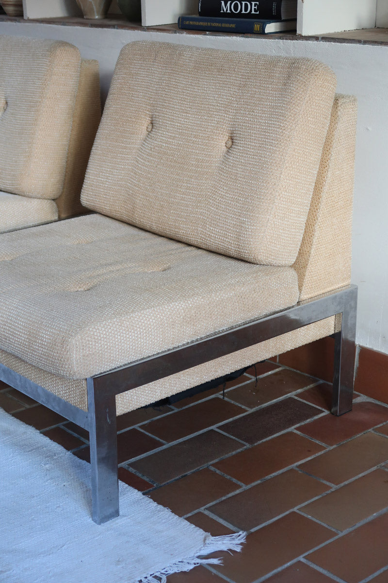 Paire de chauffeuses modernistes années 70 en acier avec tissu beige d’origine et dossier capitonné.