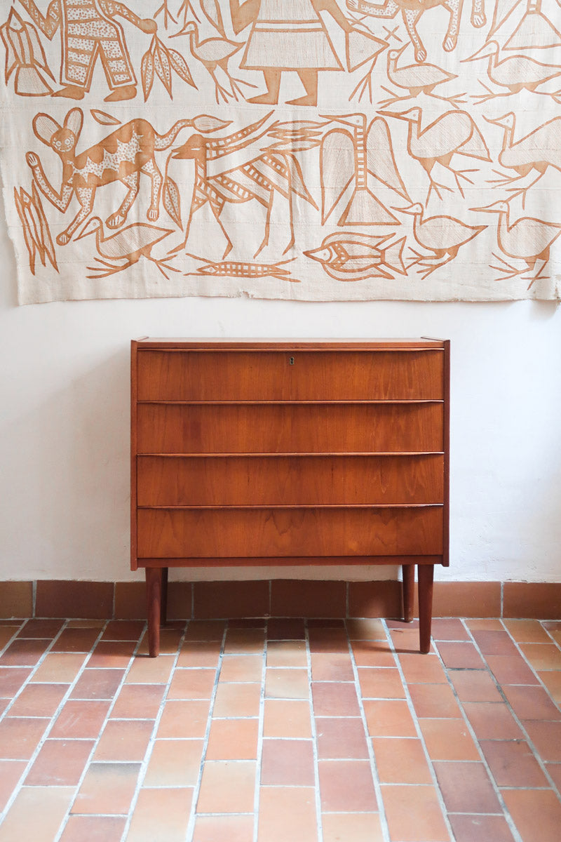Commode danoise en teck des années 60 avec quatre tiroirs et lignes sobres typiques du mobilier scandinave mid-century.