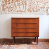 Commode danoise en teck des années 60 avec quatre tiroirs et lignes sobres typiques du mobilier scandinave mid-century.