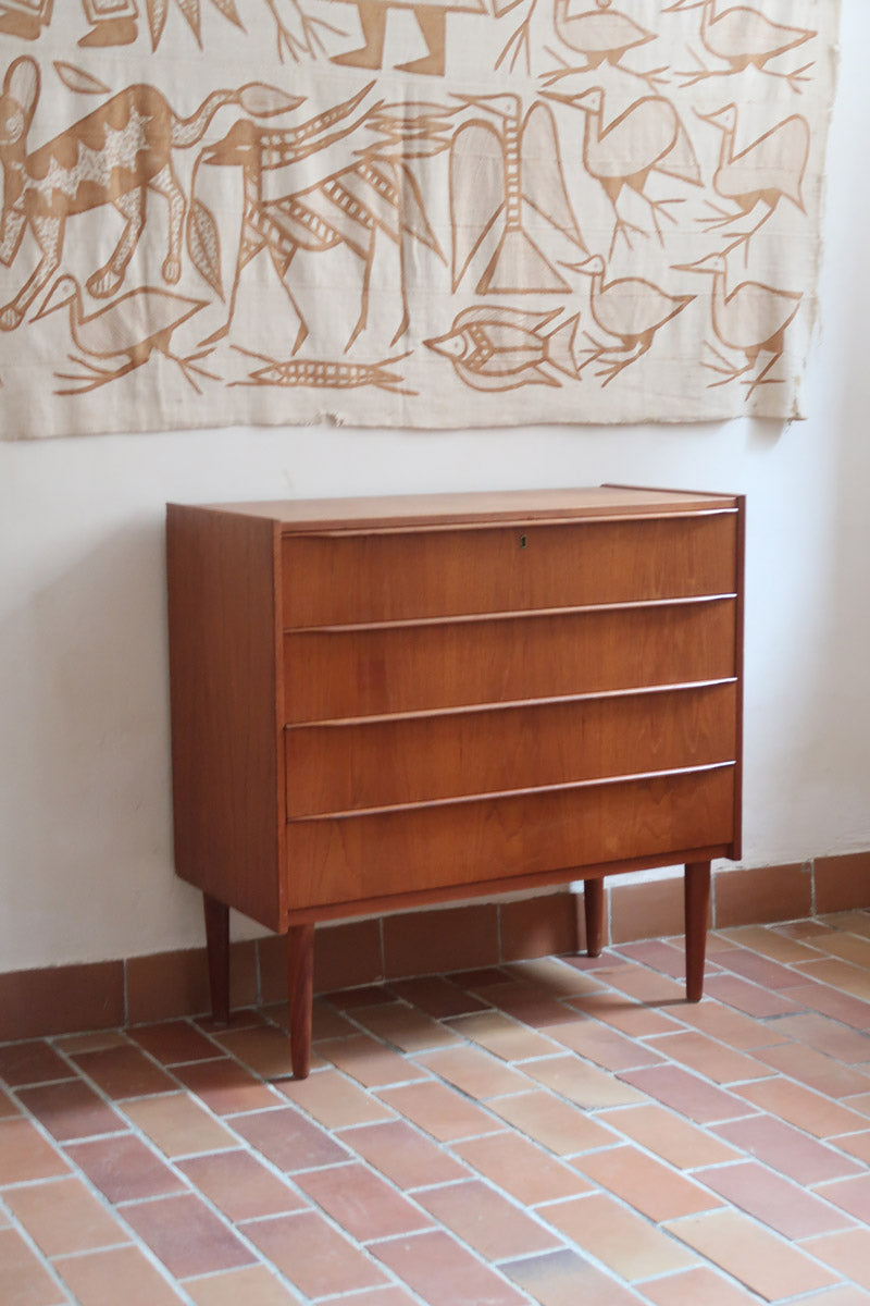 Commode danoise en teck des années 60 avec quatre tiroirs et lignes sobres typiques du mobilier scandinave mid-century.