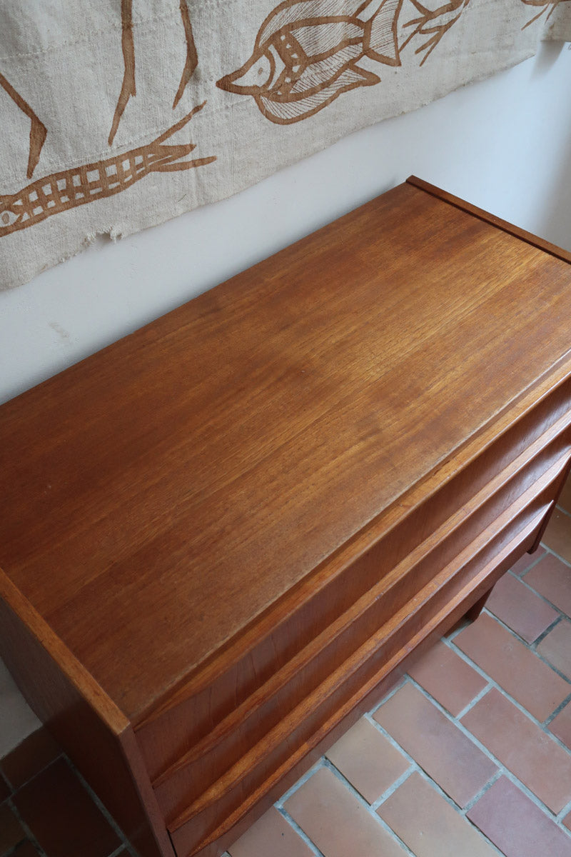 Commode danoise en teck des années 60 avec quatre tiroirs et lignes sobres typiques du mobilier scandinave mid-century.