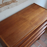 Commode danoise en teck des années 60 avec quatre tiroirs et lignes sobres typiques du mobilier scandinave mid-century.
