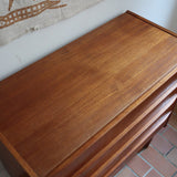 Commode danoise en teck des années 60 avec quatre tiroirs et lignes sobres typiques du mobilier scandinave mid-century.
