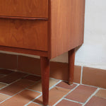 Commode danoise en teck des années 60 avec quatre tiroirs et lignes sobres typiques du mobilier scandinave mid-century.
