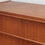 Commode danoise en teck des années 60 avec quatre tiroirs et lignes sobres typiques du mobilier scandinave mid-century.