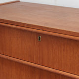 Commode danoise en teck des années 60 avec quatre tiroirs et lignes sobres typiques du mobilier scandinave mid-century.
