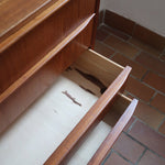 Commode danoise en teck des années 60 avec quatre tiroirs et lignes sobres typiques du mobilier scandinave mid-century.