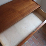 Commode danoise en teck des années 60 avec quatre tiroirs et lignes sobres typiques du mobilier scandinave mid-century.