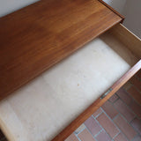 Commode danoise en teck des années 60 avec quatre tiroirs et lignes sobres typiques du mobilier scandinave mid-century.