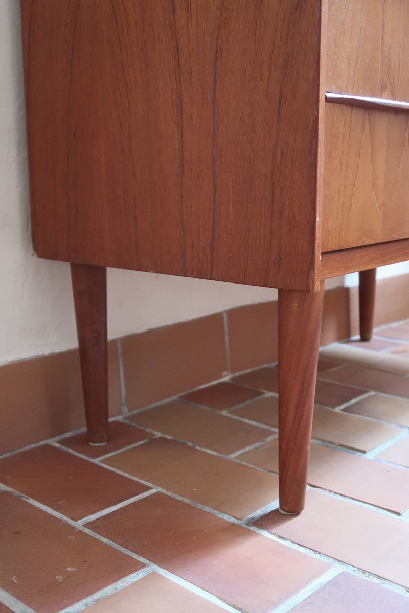 Commode danoise en teck des années 60 avec quatre tiroirs et lignes sobres typiques du mobilier scandinave mid-century.