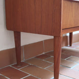 Commode danoise en teck des années 60 avec quatre tiroirs et lignes sobres typiques du mobilier scandinave mid-century.