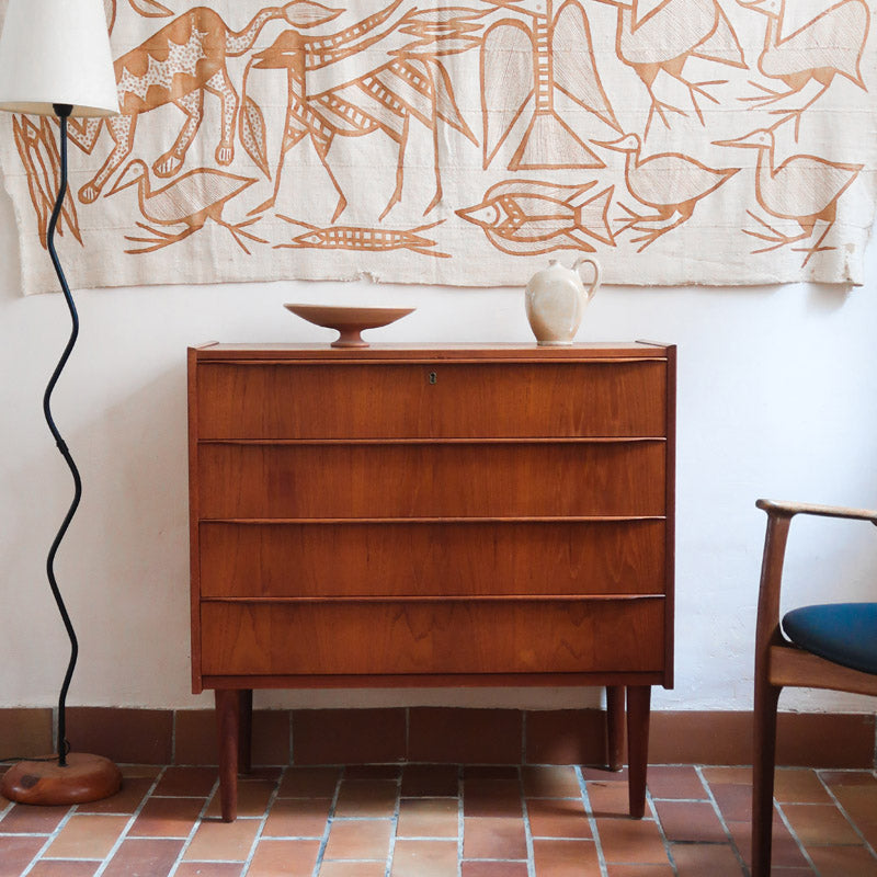 Commode danoise en teck des années 60 avec quatre tiroirs et lignes sobres typiques du mobilier scandinave mid-century.