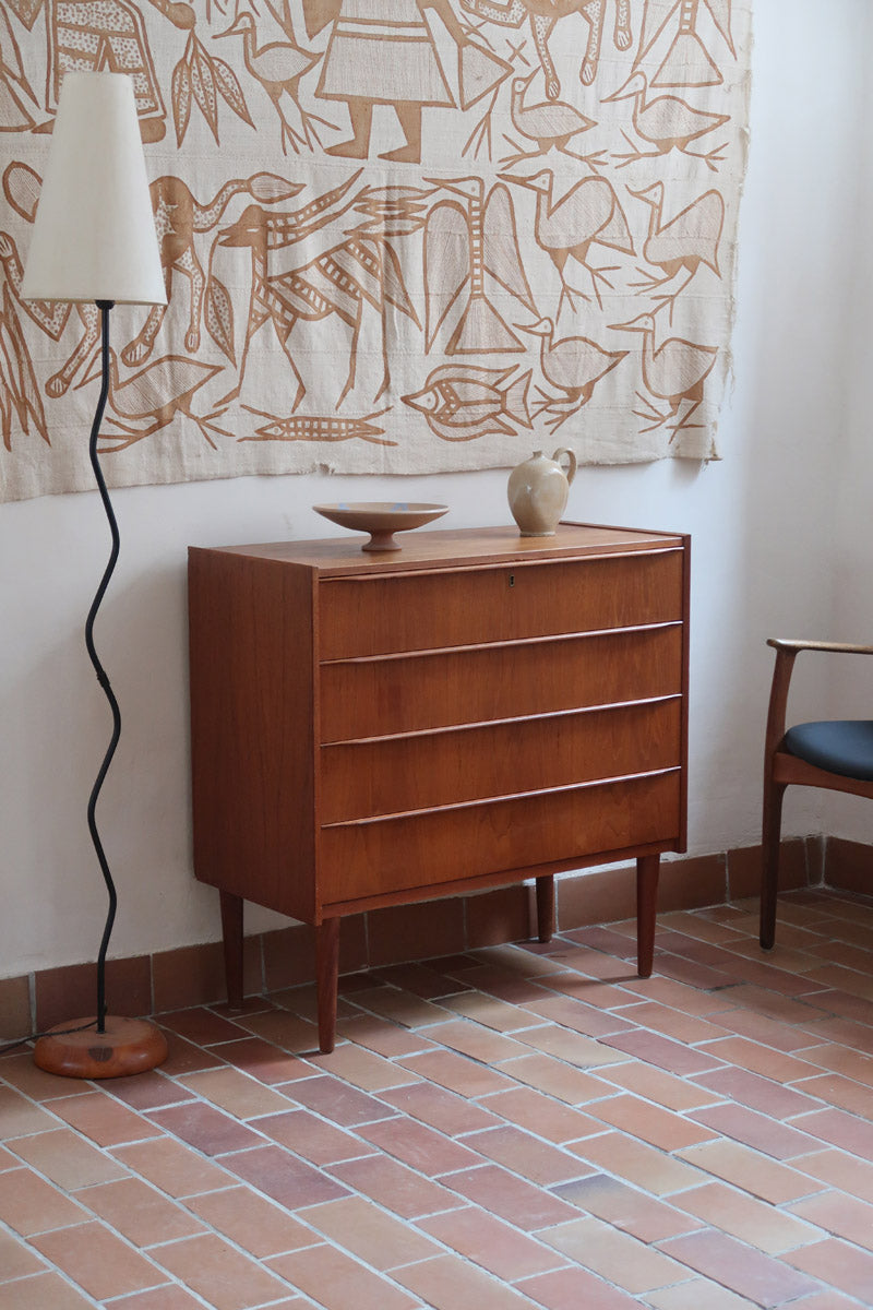 Commode danoise en teck des années 60 avec quatre tiroirs et lignes sobres typiques du mobilier scandinave mid-century.