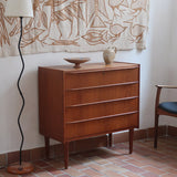 Commode danoise en teck des années 60 avec quatre tiroirs et lignes sobres typiques du mobilier scandinave mid-century.