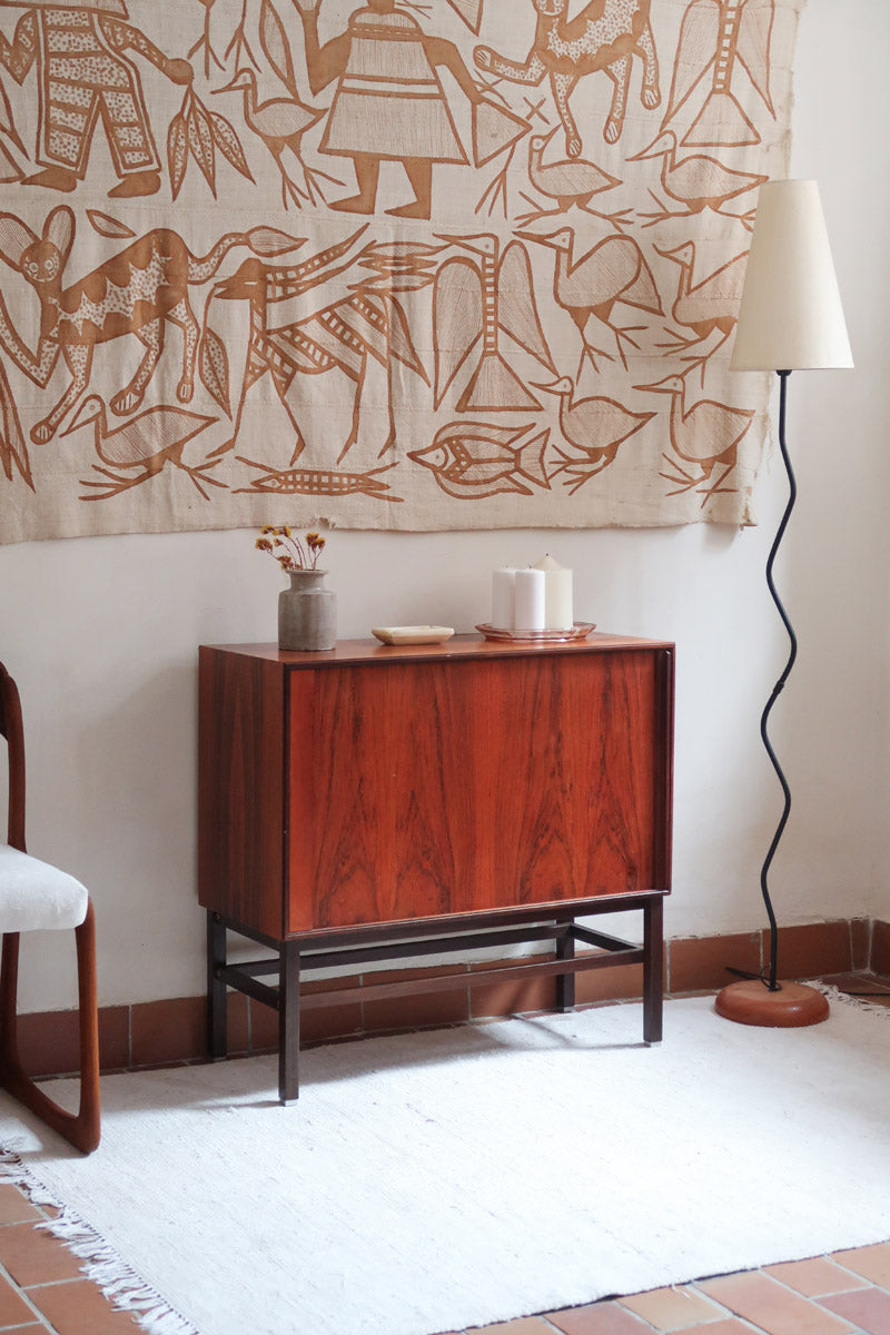 Buffet scandinave en teck années 60 à porte coulissante latérale, piètement foncé et intérieur ouvert.