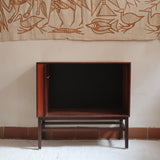 Buffet scandinave en teck années 60 à porte coulissante latérale, piètement foncé et intérieur ouvert.
