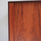 Buffet scandinave en teck années 60 à porte coulissante latérale, piètement foncé et intérieur ouvert.