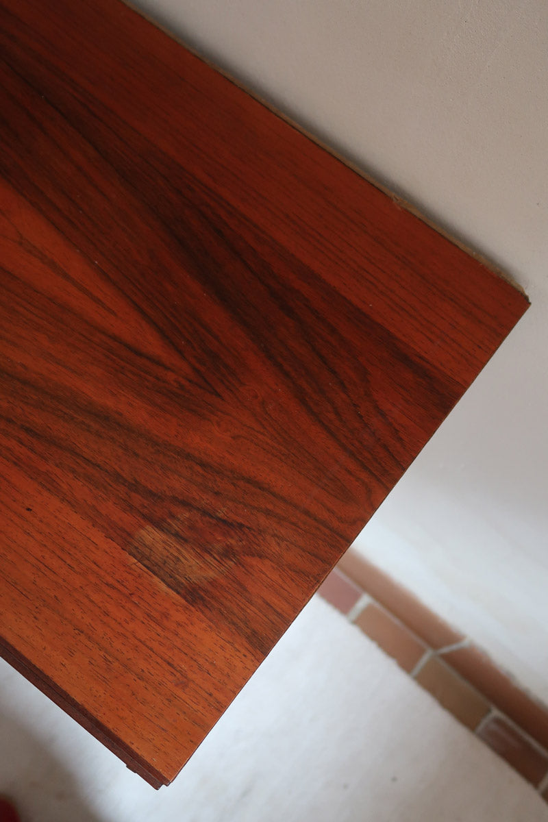 Buffet scandinave en teck années 60 à porte coulissante latérale, piètement foncé et intérieur ouvert.