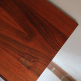 Buffet scandinave en teck années 60 à porte coulissante latérale, piètement foncé et intérieur ouvert.