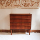Commode vintage en teck des années 60 avec quatre tiroirs, façades galbées, poignées intégrées et pieds compas.