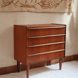 Commode vintage en teck des années 60 avec quatre tiroirs, façades galbées, poignées intégrées et pieds compas.