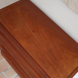 Commode danoise en teck des années 60 à quatre tiroirs, format compact et façade sobre.