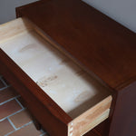 Commode danoise en teck des années 60 à quatre tiroirs, format compact et façade sobre.