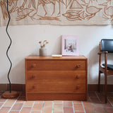 Commode danoise en teck des années 60 à trois tiroirs avec poignées carrées en bois, format bas et design mid-century.
