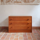 Commode danoise en teck des années 60 à trois tiroirs avec poignées carrées en bois, format bas et design mid-century.
