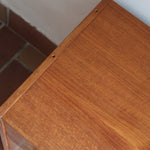 Commode danoise en teck des années 60 à trois tiroirs avec poignées carrées en bois, format bas et design mid-century.