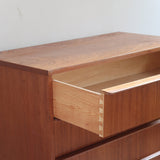 Commode scandinave en teck des années 60 avec quatre tiroirs et pieds compas, design mid century.
