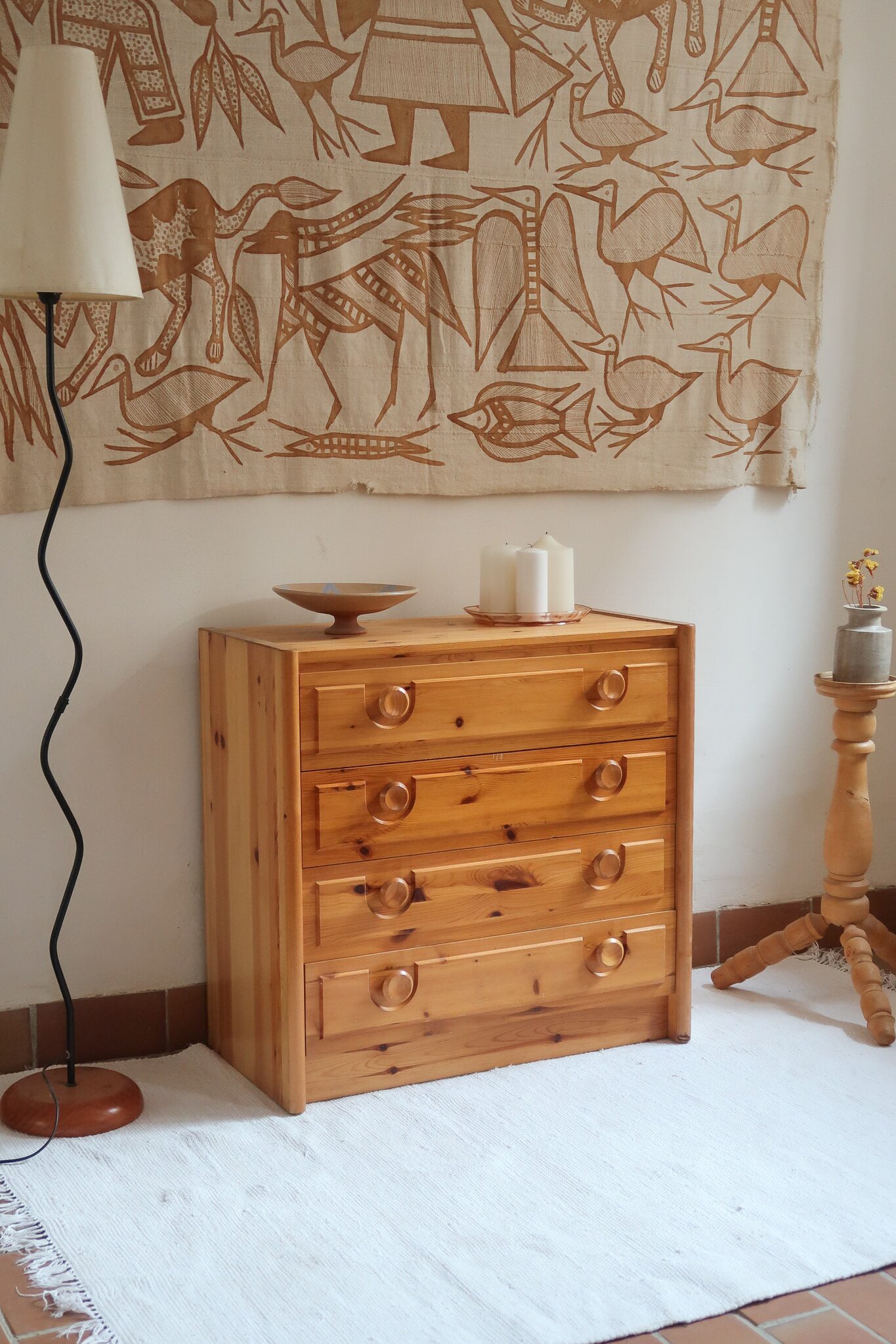Commode vintage années 70 à 4 tiroirs en pin massif, caisson à angles chanfreinés sur socle plein, poignées cuvette taillées dans la masse, style rustique montagne
