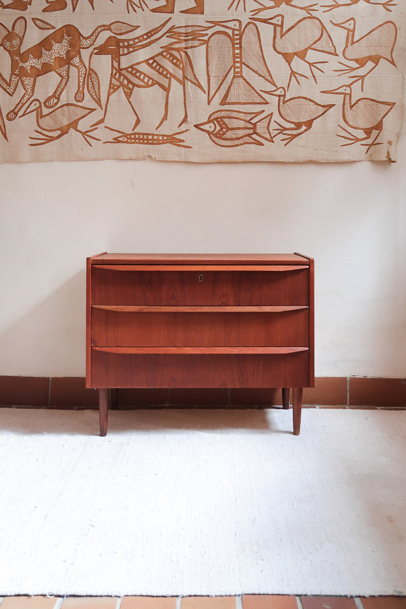 Commode scandinave en teck années 60 à trois tiroirs avec façade galbée et pieds compas.